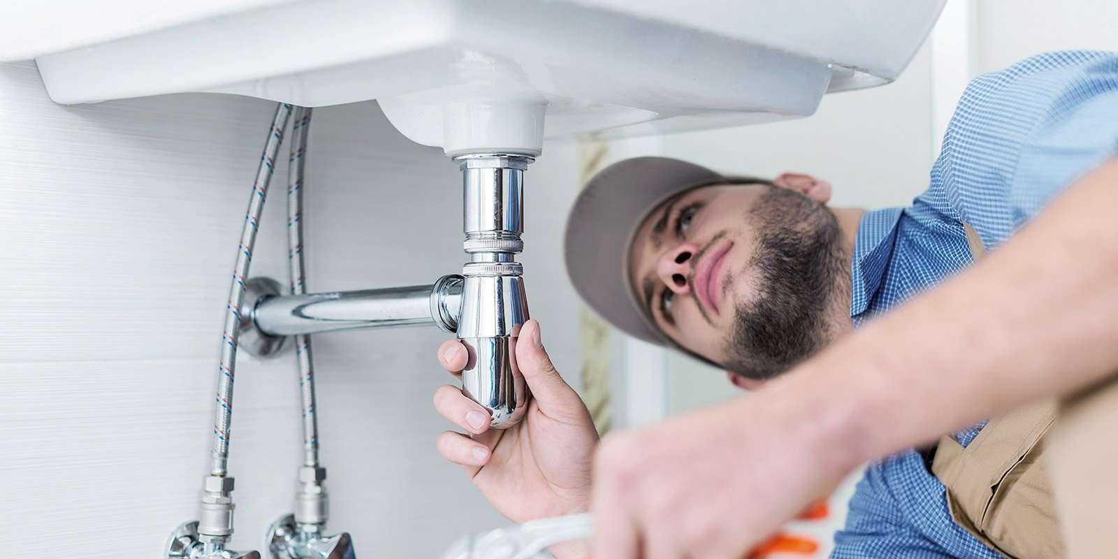 Ein Monteur unter einem Waschbecken